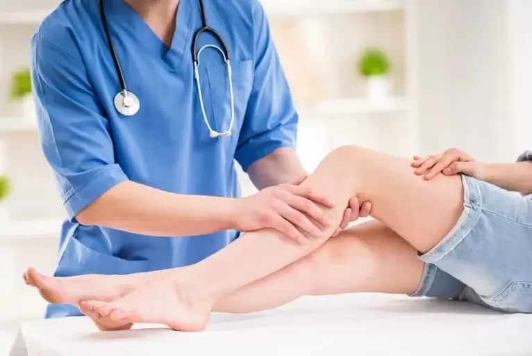 o médico examina a perna com veias varicosas